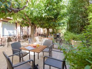 un patio extérieur avec des tables, des chaises et des arbres dans l'établissement ibis Avignon Centre Pont De L'Europe, à Avignon