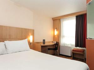 um quarto de hotel com uma cama e uma secretária em ibis Montpellier Centre Polygone em Montpellier