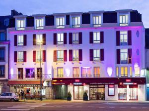 un gran edificio con ventanas coloridas en una calle en Mercure Quimper Centre, en Quimper