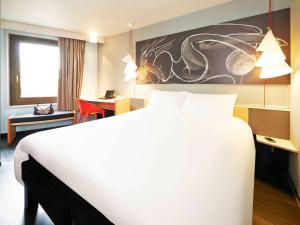 ein Hotelzimmer mit einem großen Bett und einem Schreibtisch in der Unterkunft ibis Strasbourg Centre Historique in Straßburg