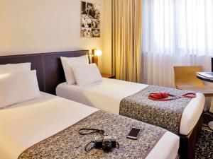 - 2 lits dans une chambre d'hôtel avec des caméras sur les lits dans l'établissement Hôtel Mercure Lyon Centre Lumière, à Lyon