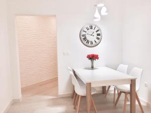 a dining room with a table and a clock on the wall at Stay Barcelona Sagrada Familia in Barcelona