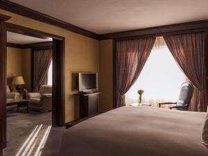um quarto de hotel com uma cama e uma televisão em Pullman Madrid Airport & Feria em Madrid