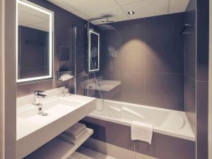 a bathroom with a sink and a bath tub at Hotel Mercure Blois Centre in Blois