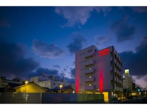 a building with a red sign on it at night at HOTEL LASCALA in Wakayama