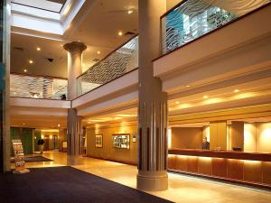 a large lobby with columns and a building at Novotel Sydney Brighton Beach in Sydney