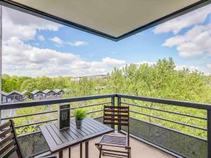 d'un balcon avec une table en bois et deux chaises. dans l'établissement ibis Paris Bercy Village, à Paris