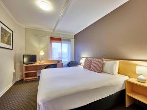 Un pat sau paturi într-o cameră la ibis Perth