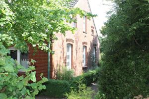 a red brick house with a garden in front of it at Ferienwohnung Mientje, 35214 in Hesel