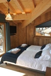 a bedroom with a bed in a wooden cabin at Chalet Teleporte in Les Gets