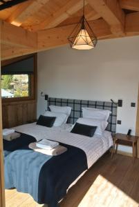 two twin beds in a room with a ceiling at Chalet Teleporte in Les Gets
