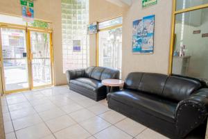 a waiting room with two leather couches and a table at OYO Hotel Casino Del Valle, Matehuala in Matehuala