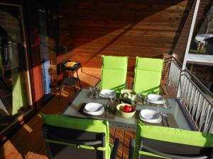 a table with green chairs on a balcony at Ferienwohnung An der Eichenallee, 35200 in Hesel