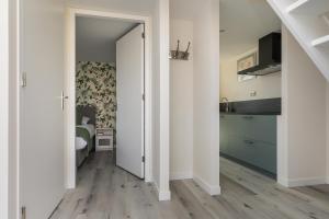 einen Flur mit einem Schlafzimmer mit einem Bett und einer Tür in der Unterkunft Appartementen Parkzicht in Bergen aan Zee