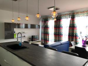 a kitchen with a sink and a living room at 189 Chezli Court in Birżebbuġa