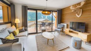 a living room with a couch and a tv and a table at Les 360 - Apt 15 - BO Immobilier in Châtel