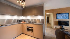 een keuken met roestvrijstalen apparatuur en een televisie bij The View - Apt 05 - BO Immobilier in Châtel
