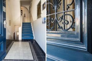 einen Flur mit blauer Tür und einer Treppe in der Unterkunft Appartementen Parkzicht in Bergen aan Zee