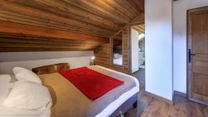 Les Montagnards - Chalet - BO Immobilier في شاتيل: غرفة نوم بسرير كبير بسقف خشبي