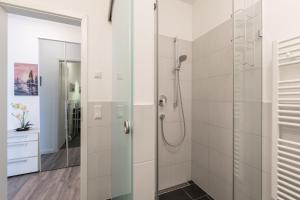 ein Bad mit einer Dusche und einer Glastür in der Unterkunft Residenz Am Meer in Börgerende-Rethwisch