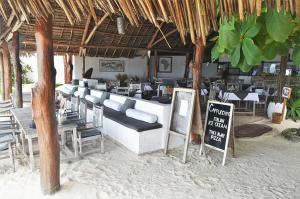 a restaurant on the beach with chairs and a sign at Sea View Lodge Boutique Hotel in Jambiani