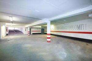 an empty parking lot with columns in a parking garage at Hotel Dolomiti Schloss in Canazei +76 photos