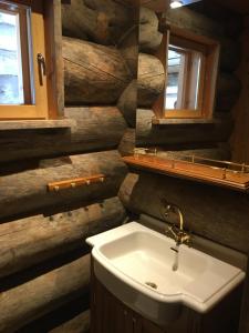 a bathroom with a sink and a wooden wall at Rukan Villa Nuotta in Ruka +19 photos