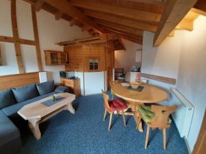 a living room with a couch and a table and chairs at Fronwieshof in Ramsau