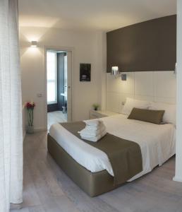 a bedroom with a large bed with towels on it at Rigel Villanova Rooms in Cagliari