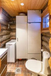 een keuken met een koelkast en een toilet bij Kuukkeli Log Houses Villa Aurora "Pupula" in Saariselkä