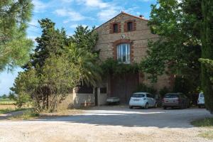 una casa con dos coches estacionados frente a ella en Domaine du Mas Bazan, en Alénya