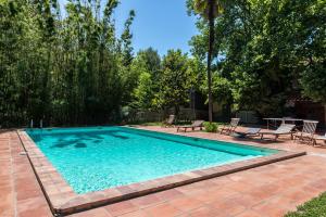 a swimming pool in a yard with chairs and trees at Domaine du Mas Bazan in Alénya