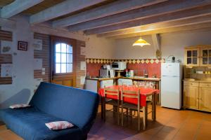 a kitchen with a blue couch and a table with chairs at Domaine du Mas Bazan in Alénya