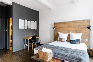ein Schlafzimmer mit einem großen Bett und einem Schreibtisch in der Unterkunft La Maison Gustave in Narbonne