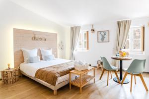 a bedroom with a bed and a table and chairs at La Maison Gustave in Narbonne