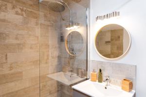 a bathroom with a sink and a glass shower at La Maison Gustave in Narbonne