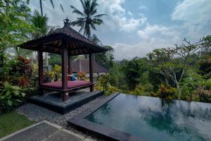 een prieel naast een zwembad bij Kaja Villa in Ubud