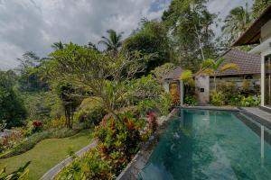 un'immagine di una piscina di fronte a una casa di Kaja Villa ad Ubud