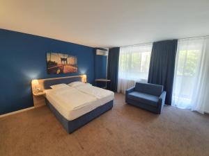 a bedroom with a large bed and a blue wall at Premium Crown Suites in Belgrade