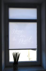 uma janela com um sinal que lê casa onde o coração está em Gemütliches Appartement mit Netflix, Nespresso und Boxspringbett em Augsburg