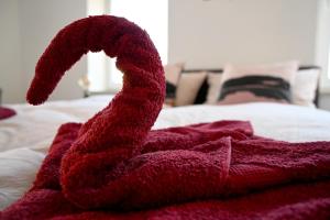 uma toalha vermelha deitada em cima de uma cama em Gemütliches Appartement mit Netflix, Nespresso und Boxspringbett em Augsburg