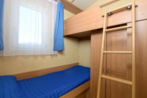 a bedroom with a bunk bed and a window at Camping Village Tuscia Tirrenica in Tarquinia