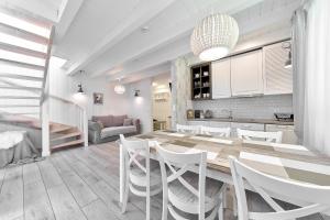 cocina y comedor con mesa y sillas en Górska Legenda Apartamenty & Domki en Szczyrk