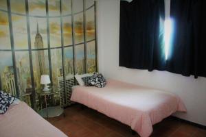 a bedroom with a bed and a painting on the wall at Aloja Ayamonte in Ayamonte