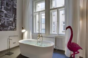 baño con bañera y flamenco rosa en BRIGHT Prague Havelská en Praga