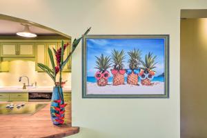 a kitchen with a painting of palm trees on the wall at Bright St Thomas Getaway with Pool, 3Mi to Magens Bay in Mafolie