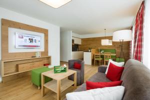 ein Wohnzimmer mit einem Sofa und einem Tisch in der Unterkunft Appartements Amarella in Bad Hofgastein