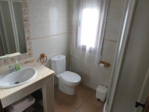 a bathroom with a white toilet and a sink at Casas Rurales Arroal in Sotoserrano