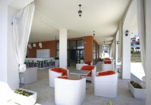 un restaurante con mesas blancas y sillas rojas en Coastal Dreams complex en Sveti Vlas