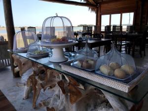 uma mesa com vários pratos de alimentos em recipientes de vidro em Vila Ybytu Eco Resort em Itarema